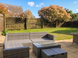A garden with outdoor sofa and coffee table at Tithe Barn, Lyneham