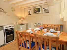 A kitchen with a dining table set with dishes at Cider Press Cottage in Priston Village, Bath