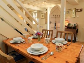 A dining room with a table set for meals at Cider Press Cottage in Priston Village, Bath
