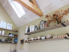 A collection of vases and bowls on shelves in a room at Bridge Studio near Broad Chalke