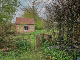 A garden with a gate leading to a house at Bridge Studio Near Broad Chalke