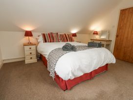 A bedroom with a double bed and bedside lamps at Droop Farm Cottage in Droop near Hazelbury Bryan