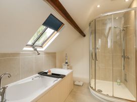 A bathroom with a bathtub and shower at Droop Farm Cottage in Droop near Hazelbury Bryan