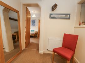 A hallway with a chair, mirror, and framed picture at Droop Farm Cottage, Droop near Hazelbury Bryan