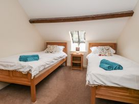 A bedroom with two single beds and a bedside table at Droop Farm Cottage Droop near Hazelbury Bryan