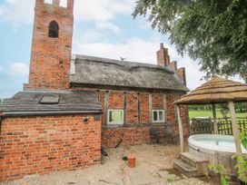 An outdoor area with a brick building and a hot tub at The Shooting Folly in Cheswardine