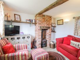 A living room with a fireplace and seating area at The Shooting Folly in Cheswardine