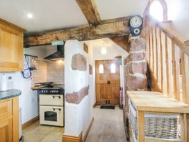 A kitchen with an oven and staircase at The Shooting Folly in Cheswardine