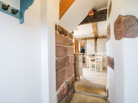 A hallway with coat hooks and stairs leading to a dining area at The Shooting Folly in Cheswardine