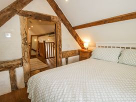 A bedroom with a bed and a door leading to a staircase at The Shooting Folly in Cheswardine