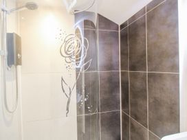 A shower with tiles and decorative design at The Shooting Folly in Cheswardine