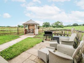 A garden with a gazebo and seating area at The Shooting Folly in Cheswardine