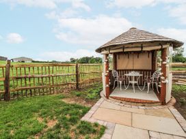 A gazebo with a table and chairs in an outdoor space at The Shooting Folly in Cheswardine