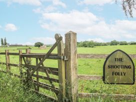 A wooden gate with a sign at The Shooting Folly in Cheswardine