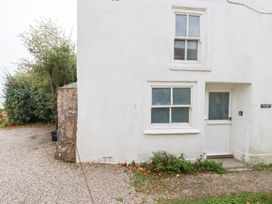 An exterior view of a white cottage with windows and door at Greeb Rocks Cottage Marazion