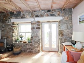 A living room with stone walls and a fireplace at Greeb Rocks Cottage, Marazion