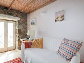 A living room with a sofa and a door to the outside at Greeb Rocks Cottage in Marazion