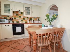 A kitchen with a dining table and chairs at Greeb Rocks Cottage, Marazion