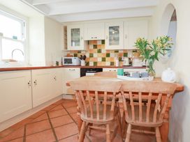 A kitchen with a wooden table and chairs at Greeb Rocks Cottage Marazion