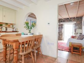 A kitchen with a wooden table and chairs at Greeb Rocks Cottage in Marazion