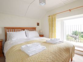A bedroom with a bed and bedside table at Greeb Rocks Cottage Marazion