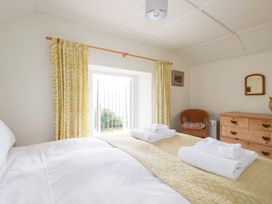 A bedroom with a bed and a window at Greeb Rocks Cottage in Marazion