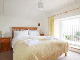 A bedroom with a bed and bedside table at Greeb Rocks Cottage in Marazion