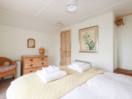 A bedroom with a bed, towels, and a dressing table at Greeb Rocks Cottage in Marazion