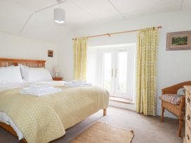 A bedroom with a bed and curtains at Greeb Rocks Cottage Marazion