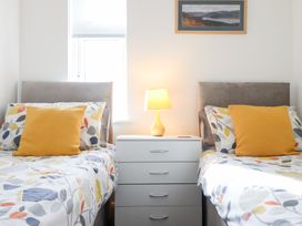 A bedroom with two beds and a nightstand at Arnant in Dolgellau