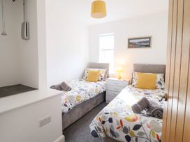 A bedroom with two beds and a bedside table at Arnant in Dolgellau