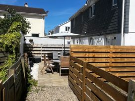 A garden with seating area and wooden fence at 8 Harlyn Mews Harlyn Bay, Cornwall