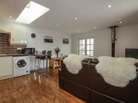 A living room with a washing machine and bar stools at The Smithy in Blisland