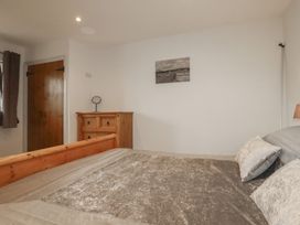 A bedroom with a bed and dresser at The Smithy in Blisland