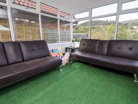 A conservatory with seating and a view at Talgais in Llangollen