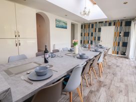 A dining room with a long table and chairs at Talgais in Llangollen