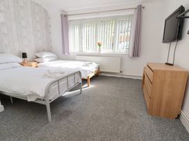 A bedroom with two beds and a television at Talgais in Llangollen