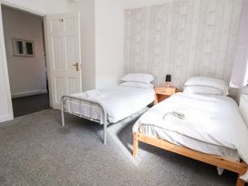 A bedroom with two beds and a nightstand at Talgais in Llangollen