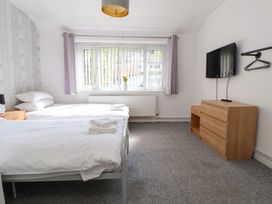 A bedroom with two beds and a television at Talgais in Llangollen