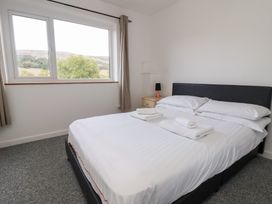 A bedroom with a bed and side table at Talgais in Llangollen