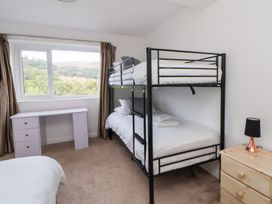 A bedroom with a bunk bed and desk at Talgais in Llangollen