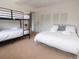 A bedroom with a bunk bed and a double bed at Talgais in Llangollen