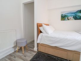 A bedroom with a bed and art on the wall at Talgais in Llangollen