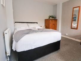 A bedroom with a bed and wardrobe at Talgais Llangollen
