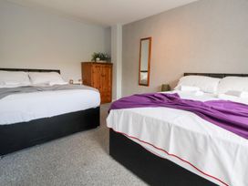 A bedroom with two beds and a wardrobe at Talgais in Llangollen