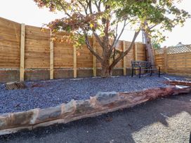 A garden with a tree and a bench at Talgais Llangollen