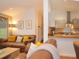 A living room with a sofa and lamp at 6 Hedgerows in Lanreath