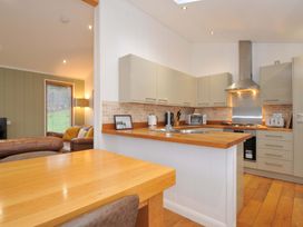 A kitchen with modern appliances and wooden dining table at 6 Hedgerows in Lanreath