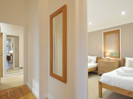 A bedroom with two beds and a lamp on a nightstand at 6 Hedgerows in Lanreath