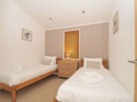 A bedroom with two beds and a nightstand at 6 Hedgerows in Lanreath